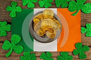 St. Patricks Day pot of chocolate gold coins and irish flag surrounded by shamrock