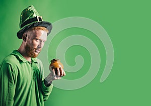 St patricks day. Patricks Day Pot of Gold and shamrocks. Red hair man in Saint Patrick`s Day leprechaun party on green photo