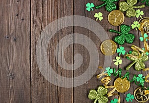 St Patricks Day side border of green shamrocks, gold coins and ribbon over a dark wood background