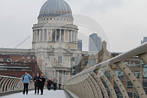 United Kingdom, London - Saint Paul Cathedral and the Millennium Bridge with tourists, foggy and cloudy day