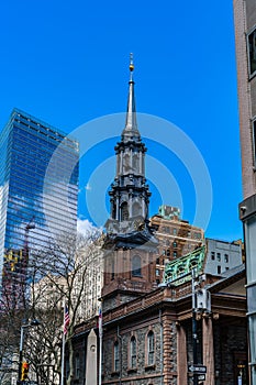 St. Paul`s Chapel of Trinity Church Wall Street in the background is Seven World Trade Center with clouds and