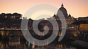 St. Peter`s Basilica in Vatican City on the Tiber River through Rome, Italy at dusk