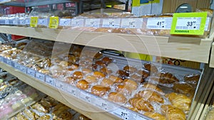Hot fresh delicious buns, cupcake in plastic wrap on supermarket shelf. Natural bakery products. Bread making and baked goods. Pro