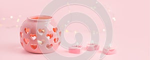 St. Valentine`s day burning candles and pink cearmic candlstick on pink background, stylish monochrome holiday card with copy