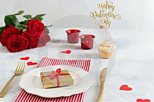 St. Valentine`s Day or romantic dinner concept. Proposal background. Romantic gift on the white plate on restaurant table with