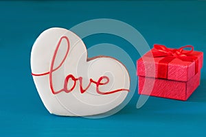 St. Valentines Day red gift box with bow and gingerbread in the shape of heart with the inscription love for holiday on