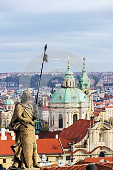 St. Wenceslas Statue in front of the Prague castle, city skyline wit St. Nicholas Church in background