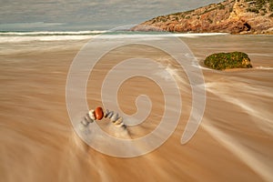 Stability stone arch with red stone at top in the morning on a beach. Wellness and nature concept. Balance concept.