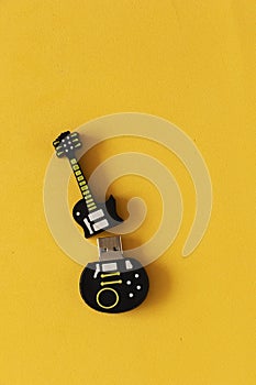 Stable usb disk in the form of a guitar on a yellow table. Files saved on usb disk.