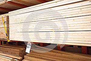 Stack of 2x4 10 feet long stud pine lumber with price tag at home improvement hardware store shelves uses for framing, houses,