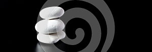 Stack of 3 white zen rocks piled up on a black background