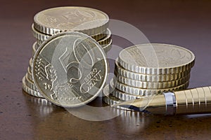 Stack of 50 cents euro coins and pen