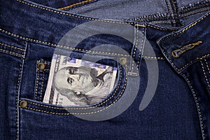 Stack of American hundred dollar bills in a pocket of blue jeans. Money in your pocket, cash