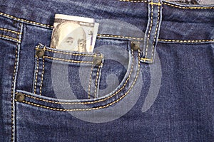 Stack of American hundred dollar bills in a pocket of blue jeans. Money in your pocket, cash