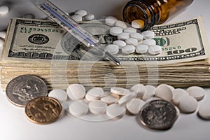 Stack of american money with medicine, pills and clinical thermometer on stack of Dollar cash