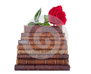 Stack of antique books and red rose