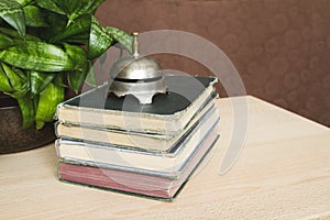 Stack of antique books with a vintage bell on top