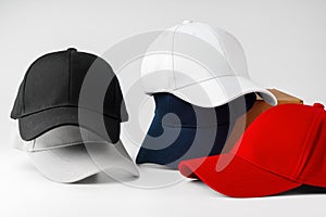 Stack of Assorted Baseball Caps on a White Background