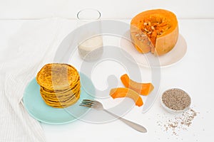 A stack of autumn pumpkin pancakes with Chia seeds and honey on a light background. delicious healthy vegetarian diet Breakfast.