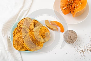 A stack of autumn pumpkin pancakes with Chia seeds and honey on a light background. delicious healthy vegetarian diet Breakfast.