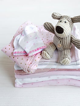 Stack of baby clothes, socks and knitted toy