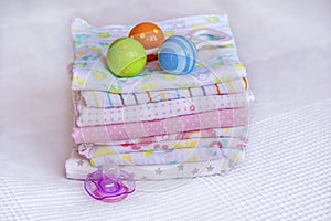 Stack of baby diapers and  baby rattle