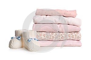 Stack of baby girl`s clothes and booties on white