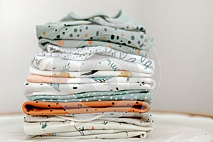 stack of baby onesies with unisex patterns