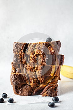 Stack of banana bread slices with blueberries on a gray background. Close up