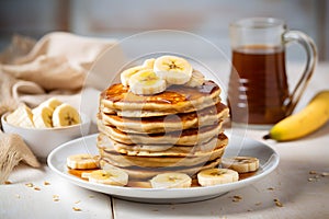 Stack of banana pancakes with honey syrup on plate