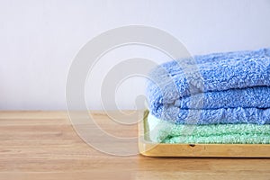 Stack of bath towels on light wooden background