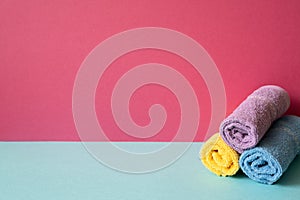 Stack of bathroom shower towels on skyblue shelf. pink wall background