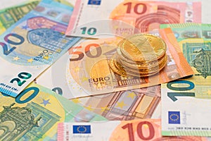 A Stack of Bitcoin Coins on the Euro Banknotes