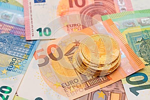 A Stack of Bitcoin Coins on the Euro Banknotes