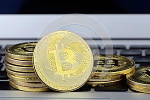 Stack of Bitcoin coins on laptop keyboard. Cryptocurrency. Selective focus