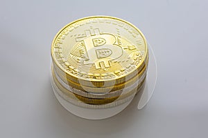 Stack of bitcoins and other crypto currencies on a white table