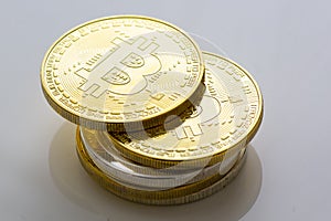 Stack of bitcoins and other crypto currencies on a white table