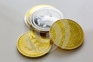 Stack of bitcoins and other crypto currencies on a white table