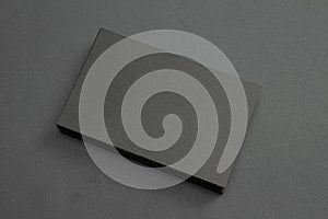 Stack of black blank textured business cards on dark paper background, us size 3.5 x 2 inches, as template for design presentation