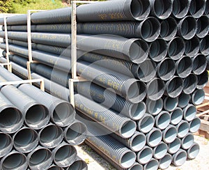 Stack of black corrugated plastic pipes