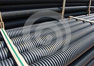 Stack of black corrugated plastic pipes