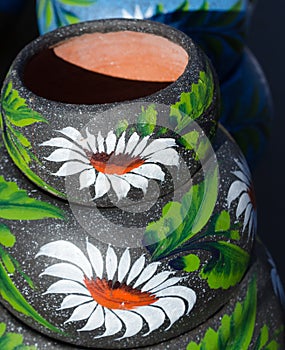 Stack of black mexician ceramic pots with green flowers