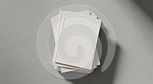 A stack of blank white cards casts a shadow on a smooth gray surface