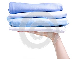 Stack blue folded clothing in hand