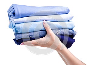 Stack blue folded clothing in hand