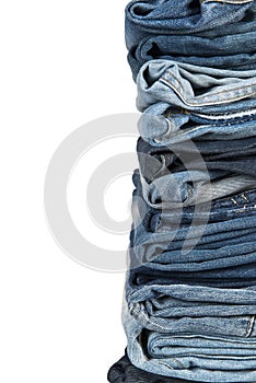 Stack of blue jeans over a white background