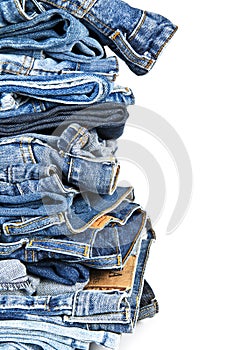 Stack of blue jeans over a white background