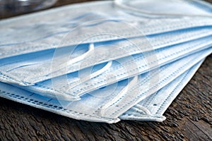 A stack of blue surgical earloop face mask destined to prevent the spread of coronavirus COVID-19 pandemic