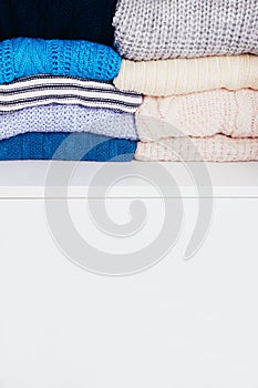 Stack of blue sweaters on a wooden background
