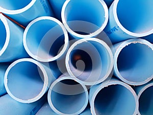 Stack of blue water pvc pipe on the rack background texture cut to edge